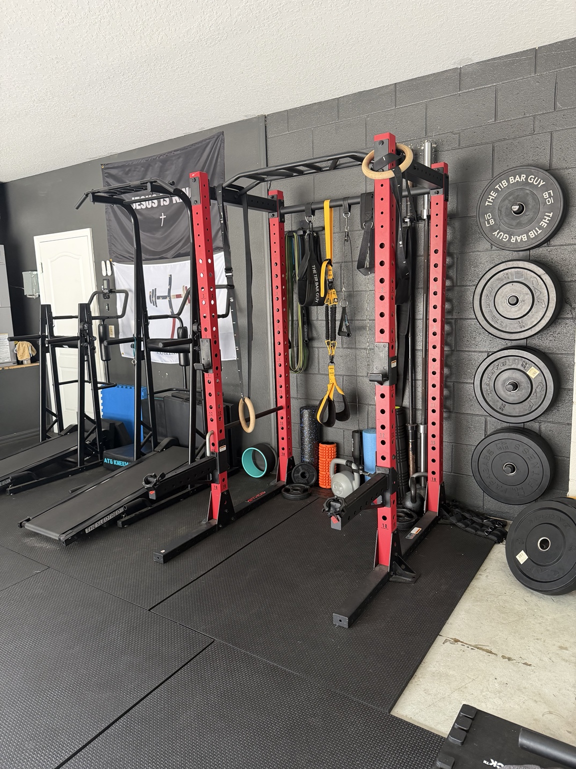 Power rack, rings, resistance bands, weights, and mobility equipment in Nick’s private gym