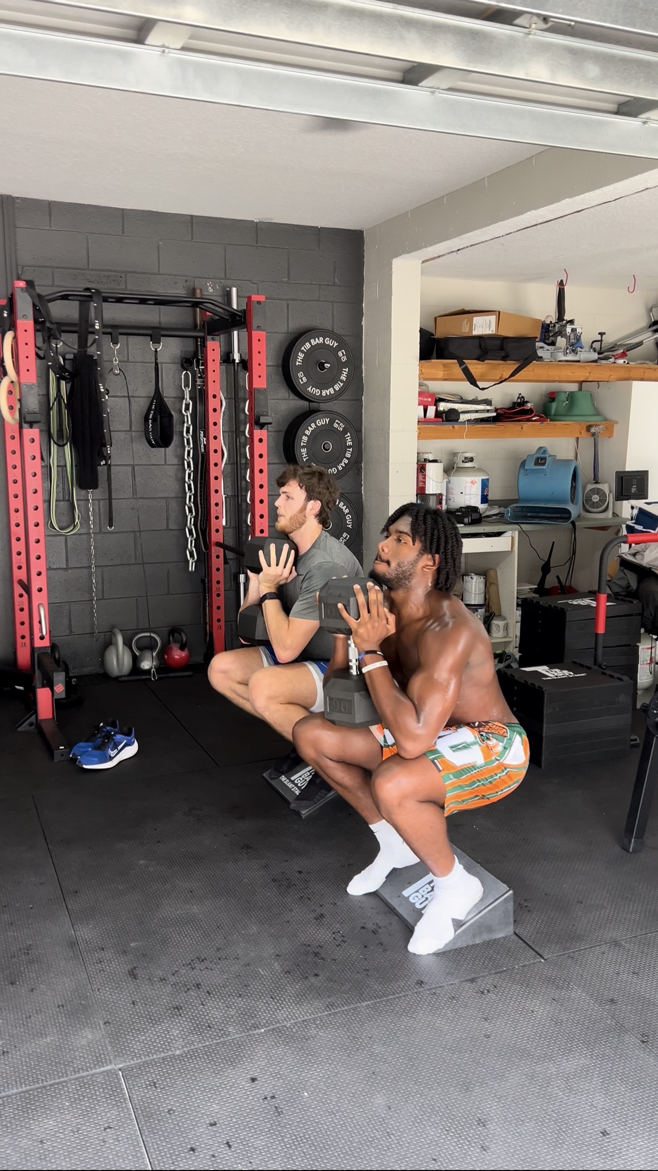 Two college athletes performing weighted squats together