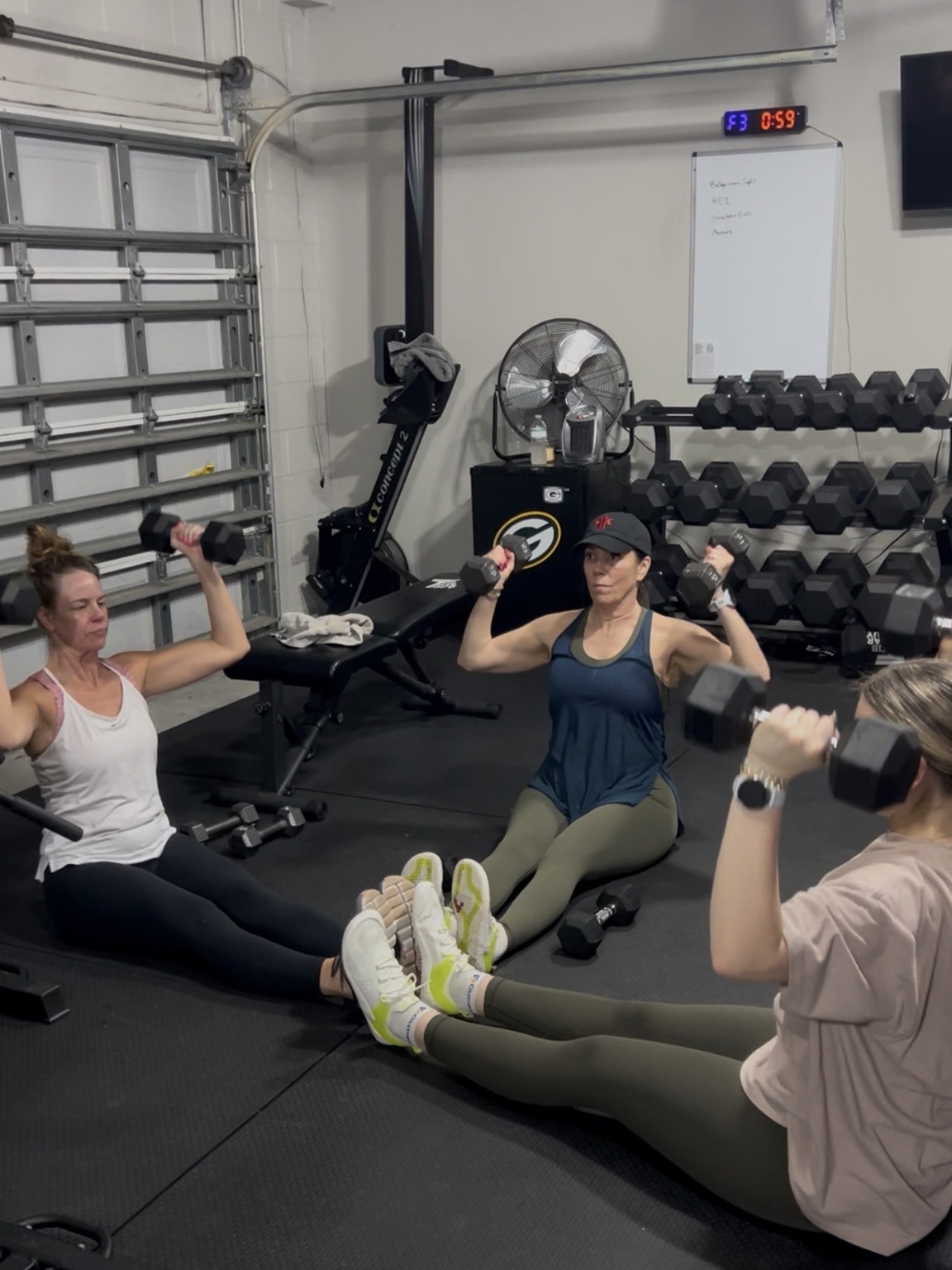 Three women strength training together with dumbbells in Nick’s private gym