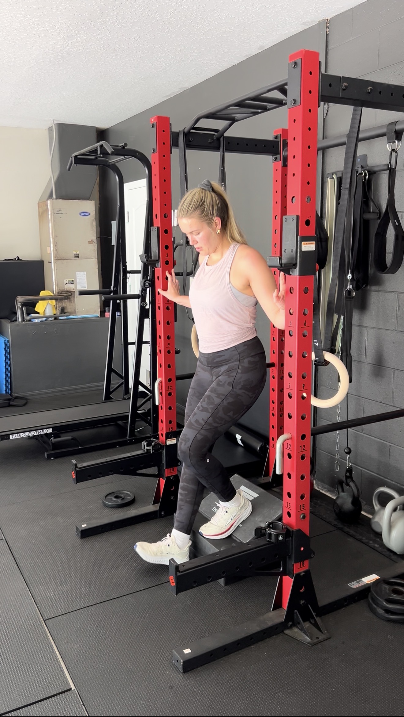 A woman working through a controlled lower-body exercise in Nick’s private gym